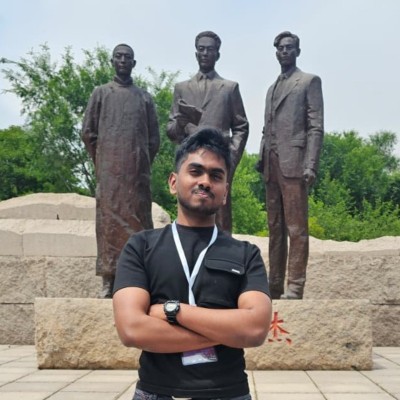 Senithu Dampegama standing in front of a bronze sculpture group
