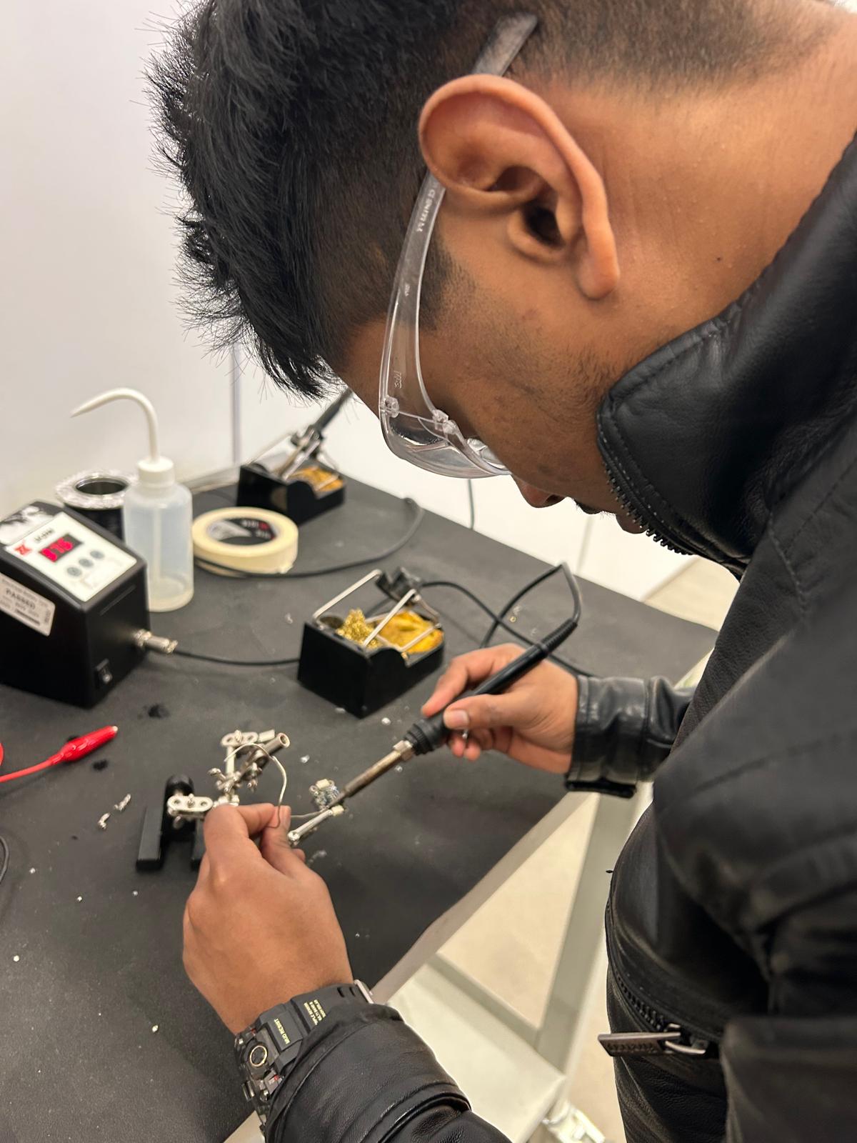 Senithu soldering the light sensor subsystem at the bench